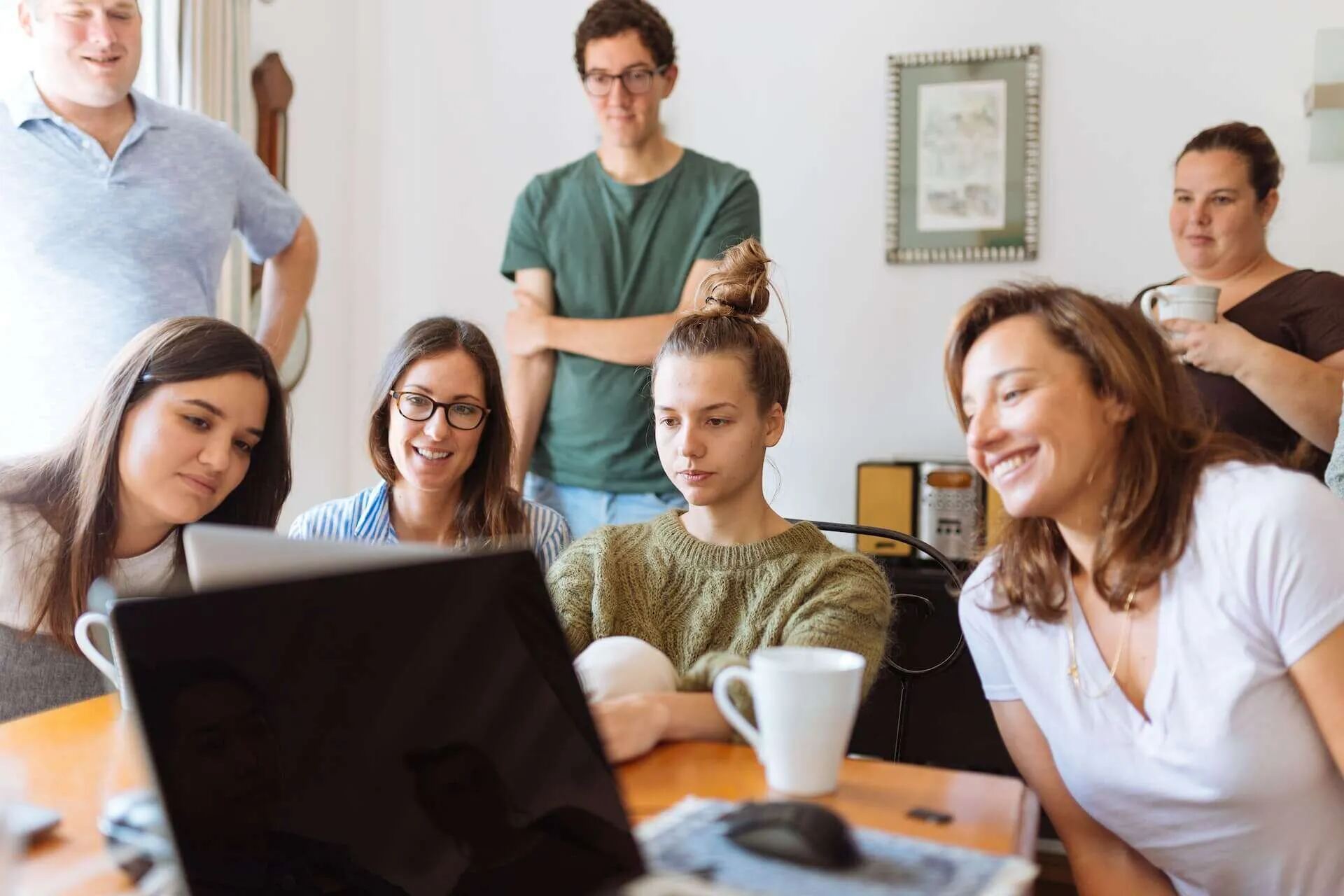 A group gathered around a laptop